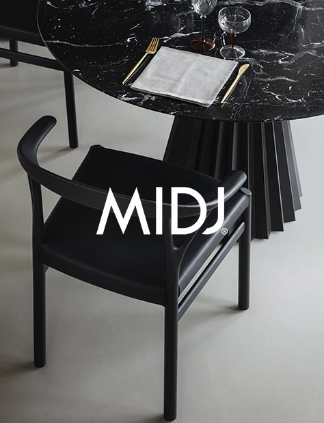Mesa Pliss&eacute; de Midj con estructura met&aacute;lica y sobre cristalcer&aacute;mico, junto a silla Oslo negra en ambiente moderno